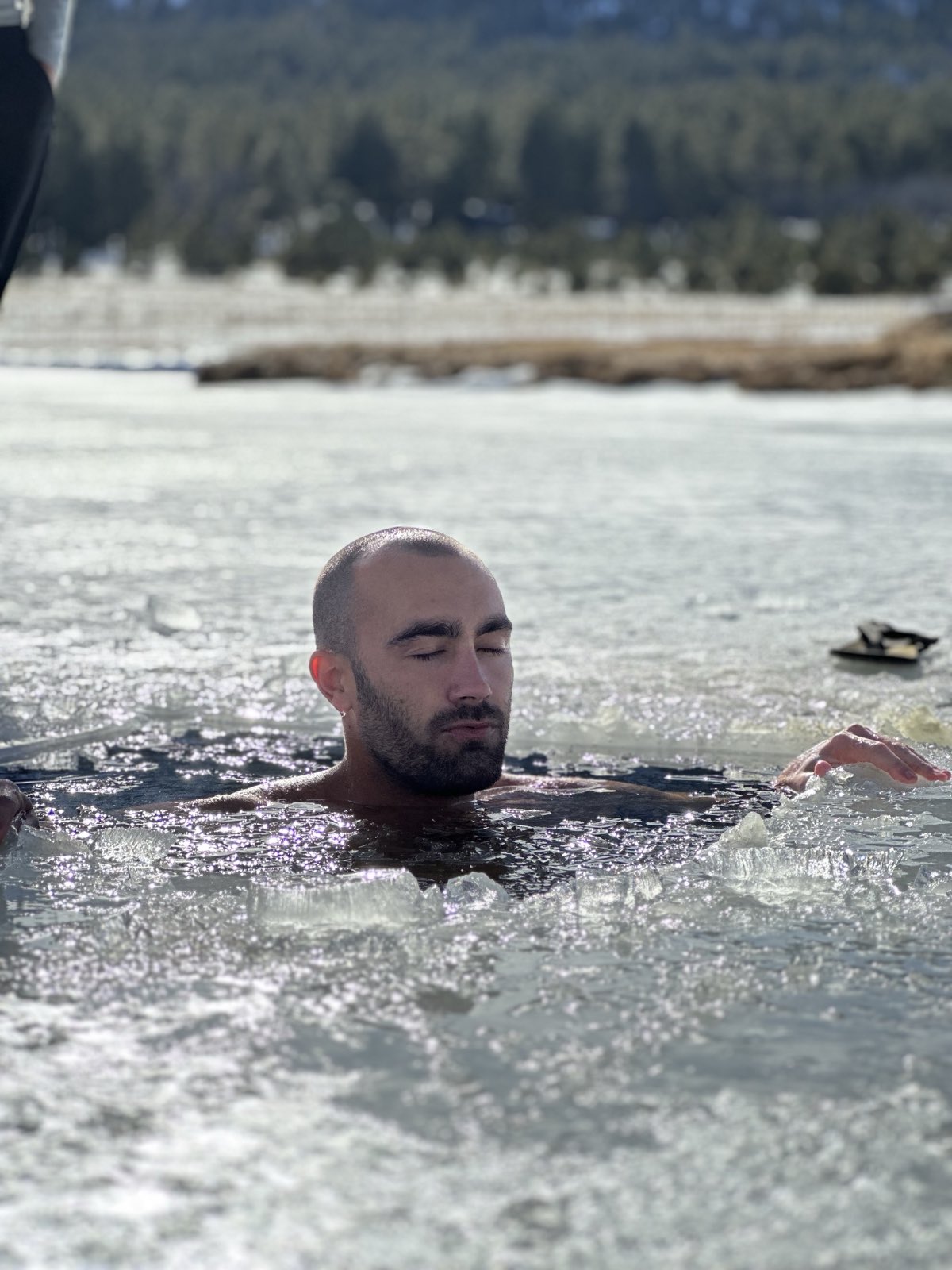 Ryan McBurney doing a cold-water ice bath outdoors, eyes closed