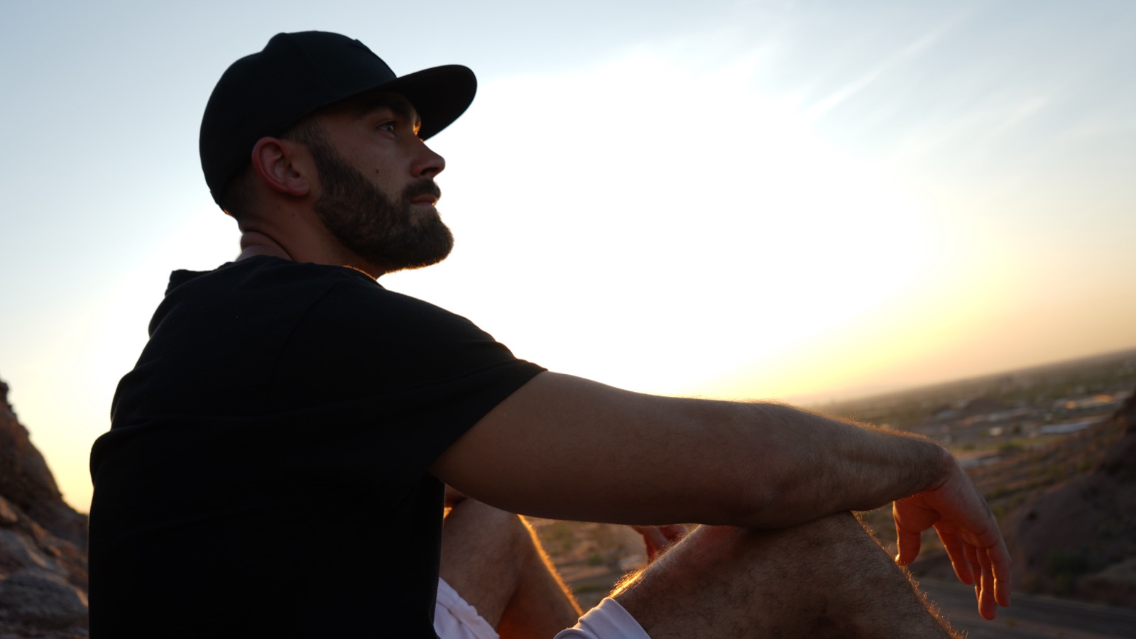 Ryan McBurney in profile overlooking the Phoenix desert at sunset, contemplative