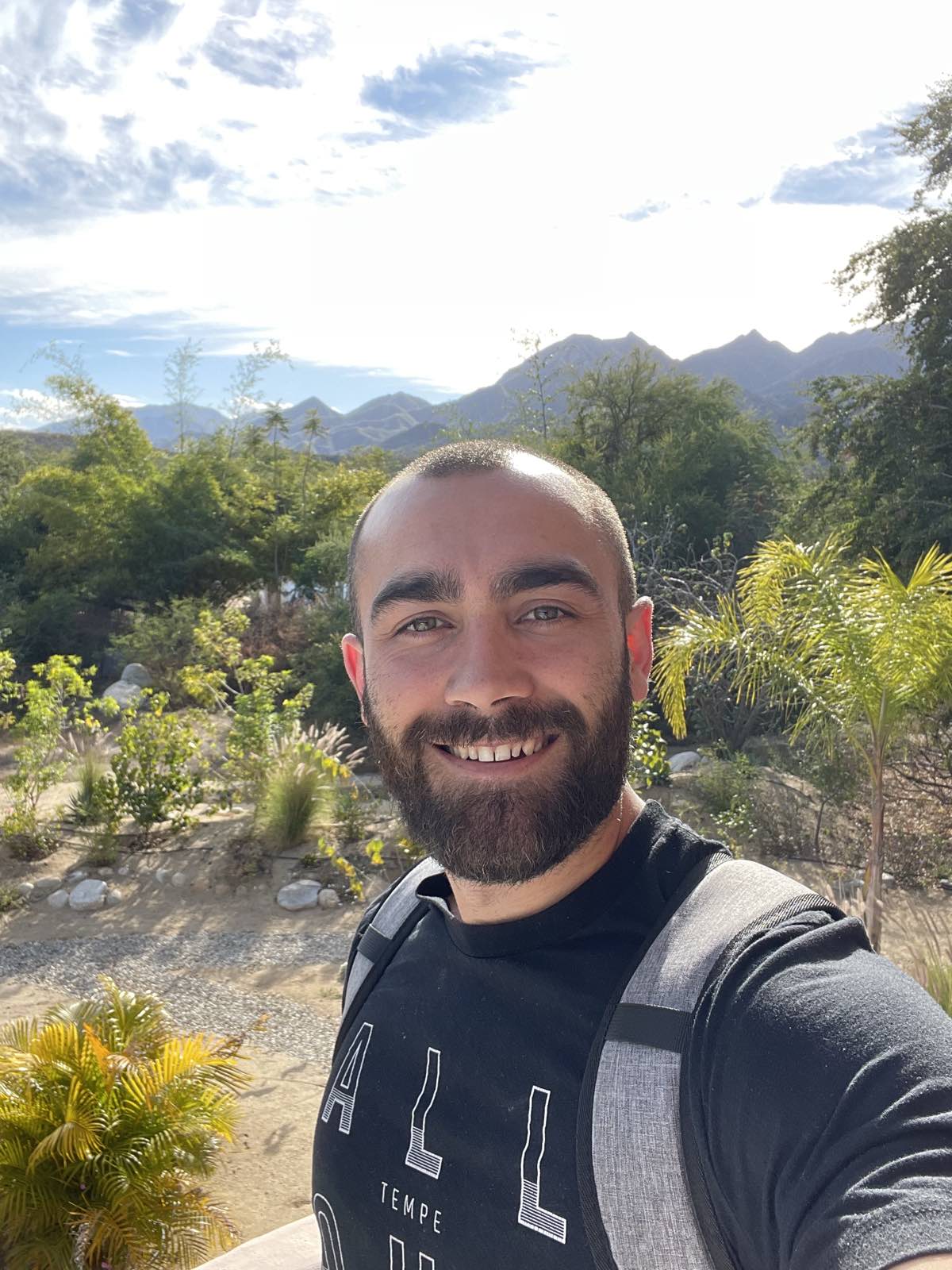 Ryan McBurney smiling, Arizona desert mountains and palms in the background