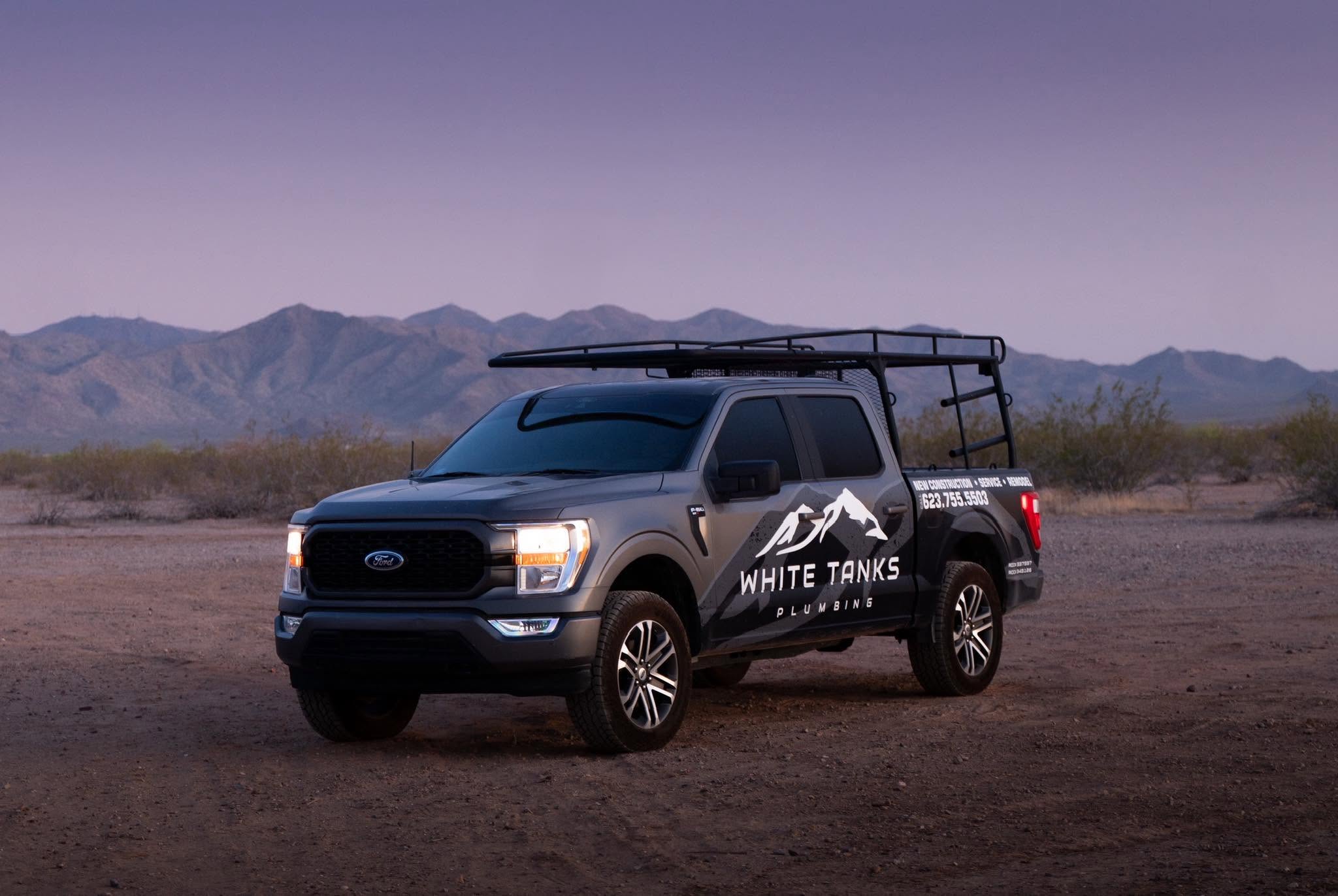 White Tanks Plumbing work truck in the Arizona desert at dusk with the White Tank Mountains behind it